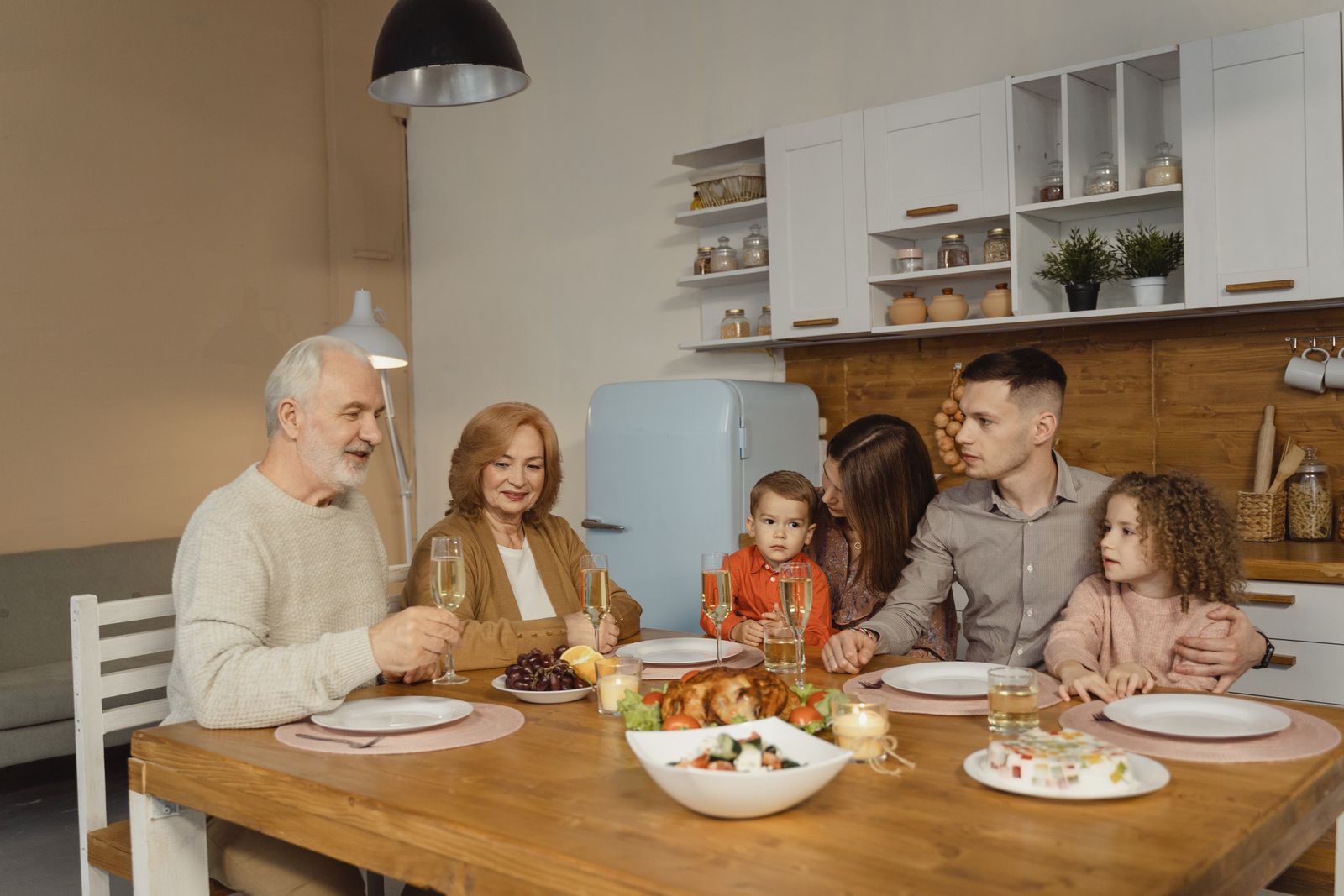 Família reunida à mesa, luz quente.